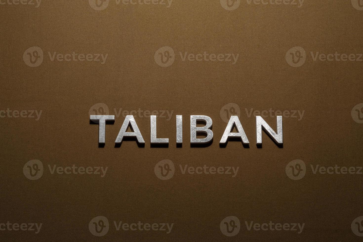 il parola taliban di cui con argento metallo lettere su ruvido abbronzatura cachi tela tessuto foto