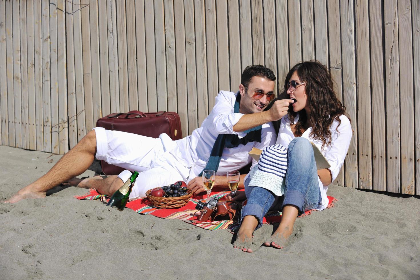 giovane coppia godendo picnic su il spiaggia foto