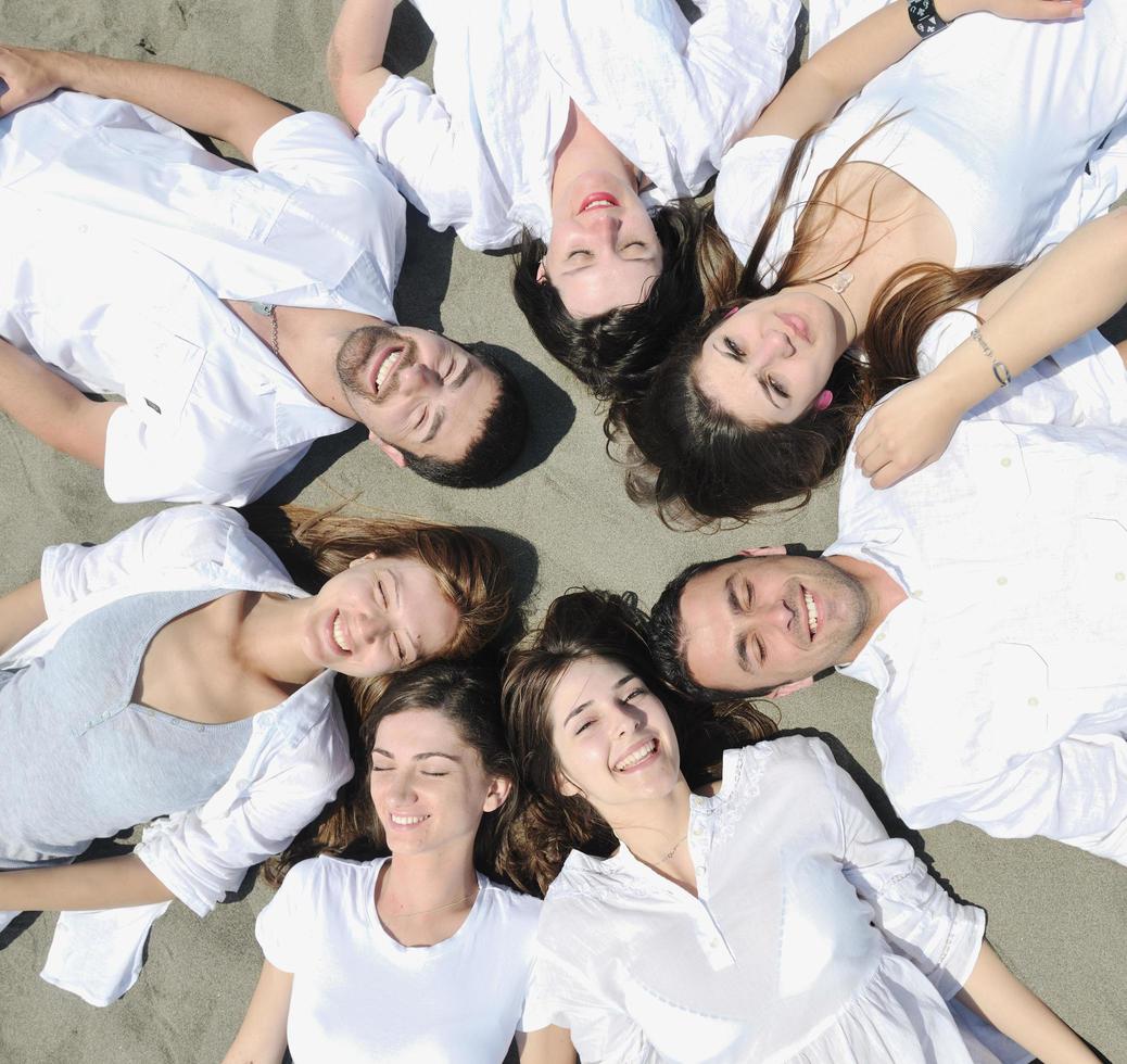 gruppo di contento giovane persone nel avere divertimento a spiaggia foto