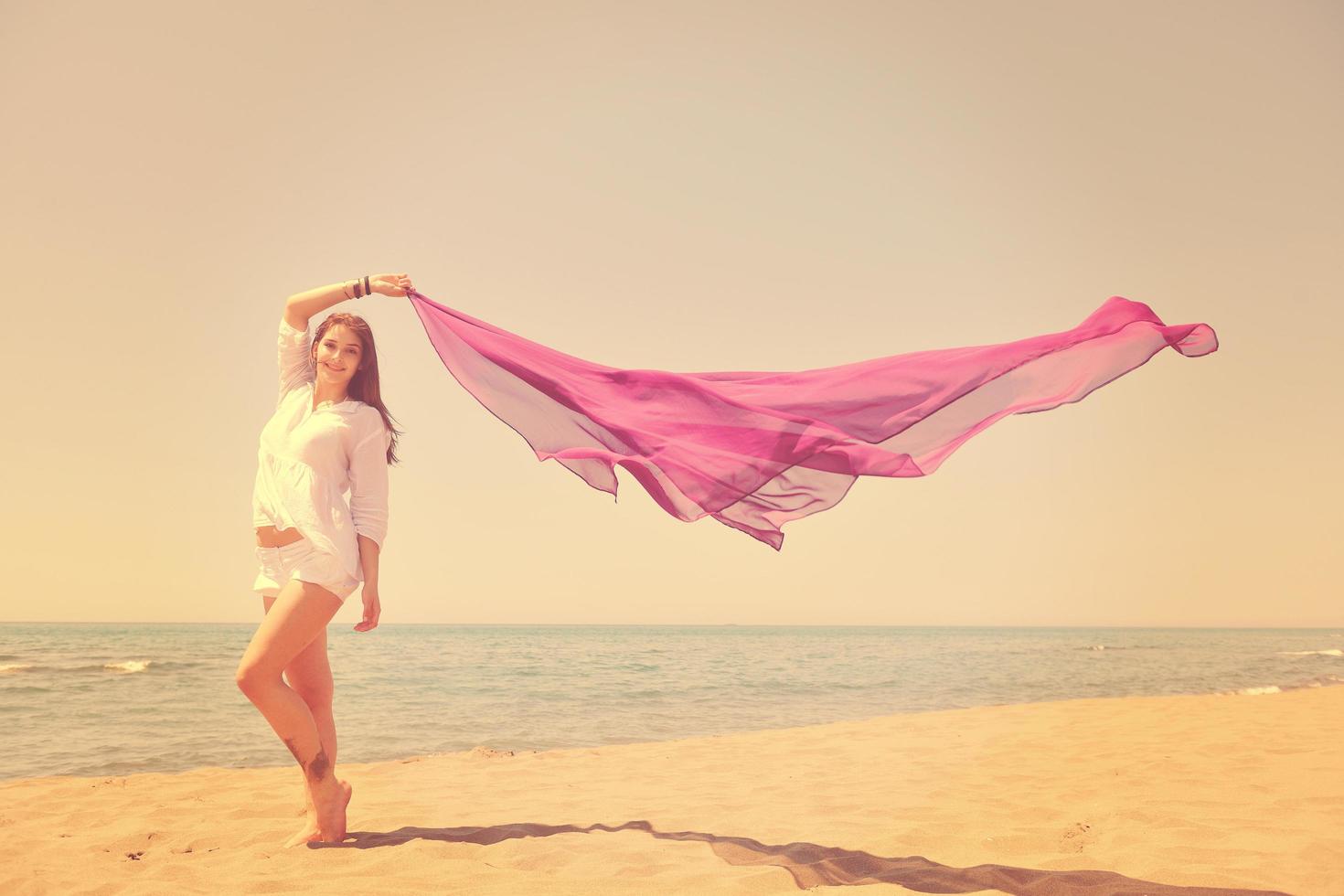 bellissimo giovane donna su spiaggia con sciarpa foto