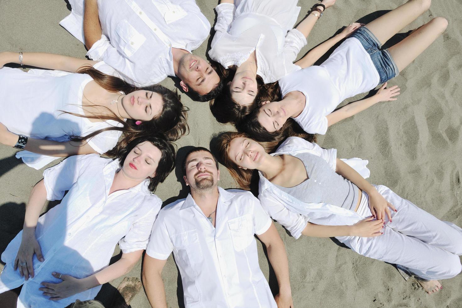 gruppo di contento giovane persone nel avere divertimento a spiaggia foto