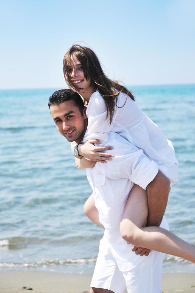 la giovane coppia felice si diverte sulla spiaggia foto