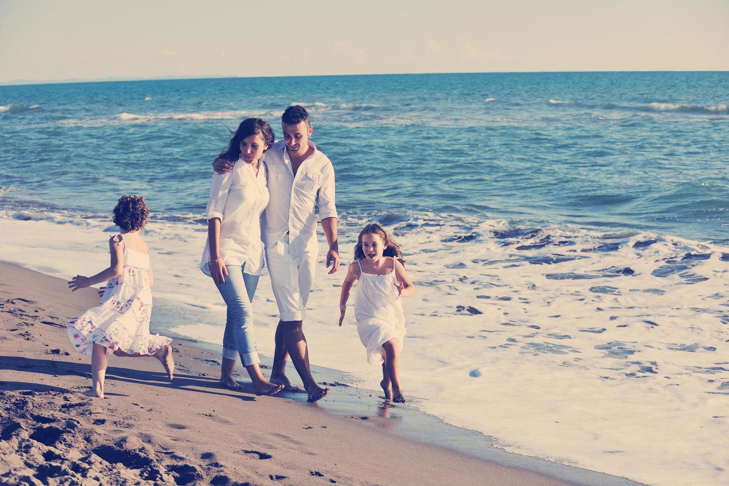 contento giovane famiglia avere divertimento su spiaggia foto