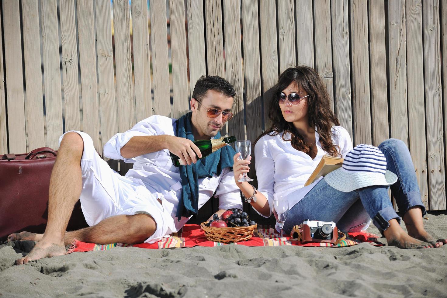 giovane coppia godendo picnic su il spiaggia foto