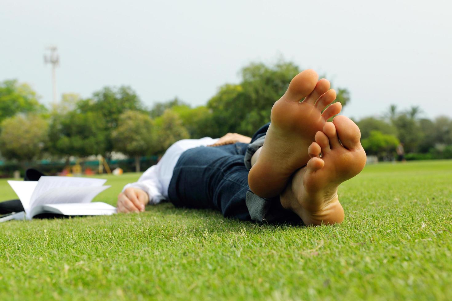 giovane donna che legge un libro nel parco foto