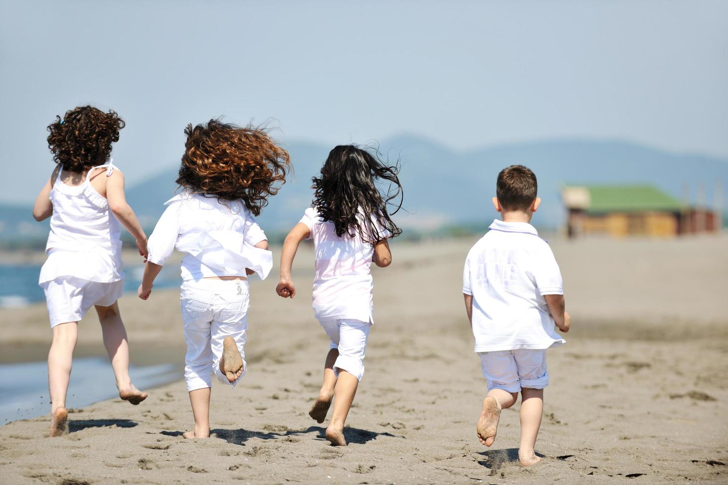 gruppo di bambini felici che giocano sulla spiaggia foto