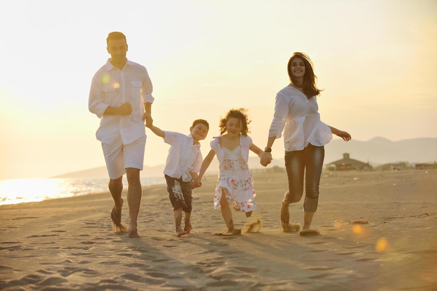 contento giovane famiglia avere divertimento su spiaggia foto