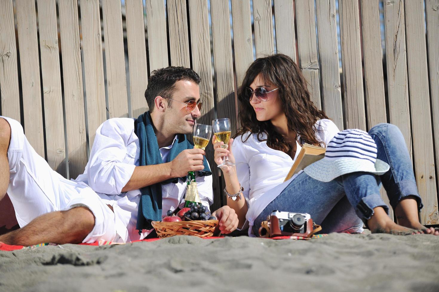 giovane coppia godendo picnic su il spiaggia foto