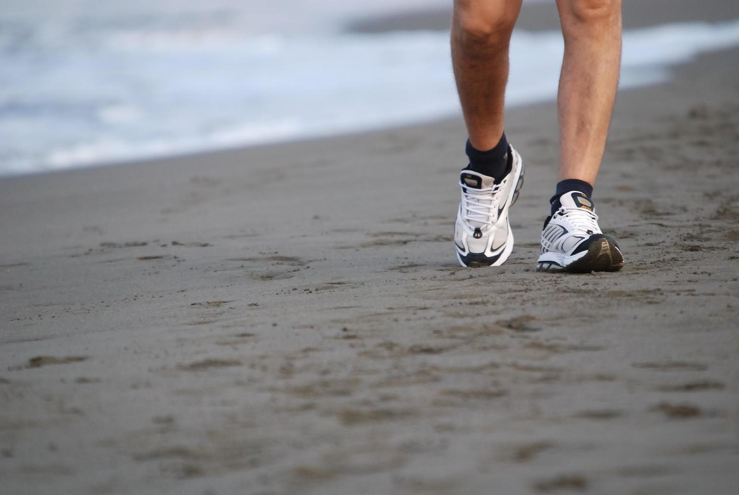 uomo a piedi su spiaggia foto