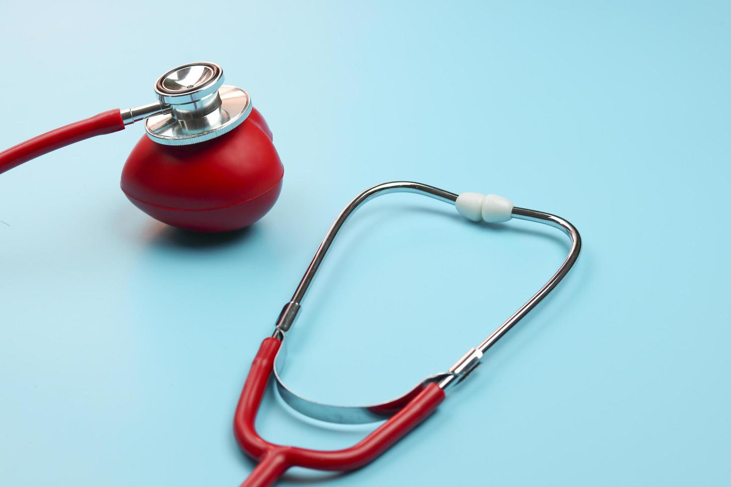 stetoscopio e cuore rosso su sfondo blu foto