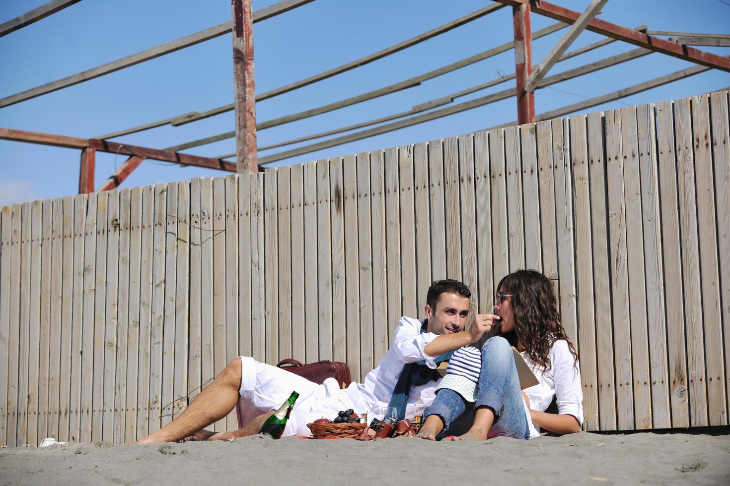 giovane coppia godendo picnic su il spiaggia foto