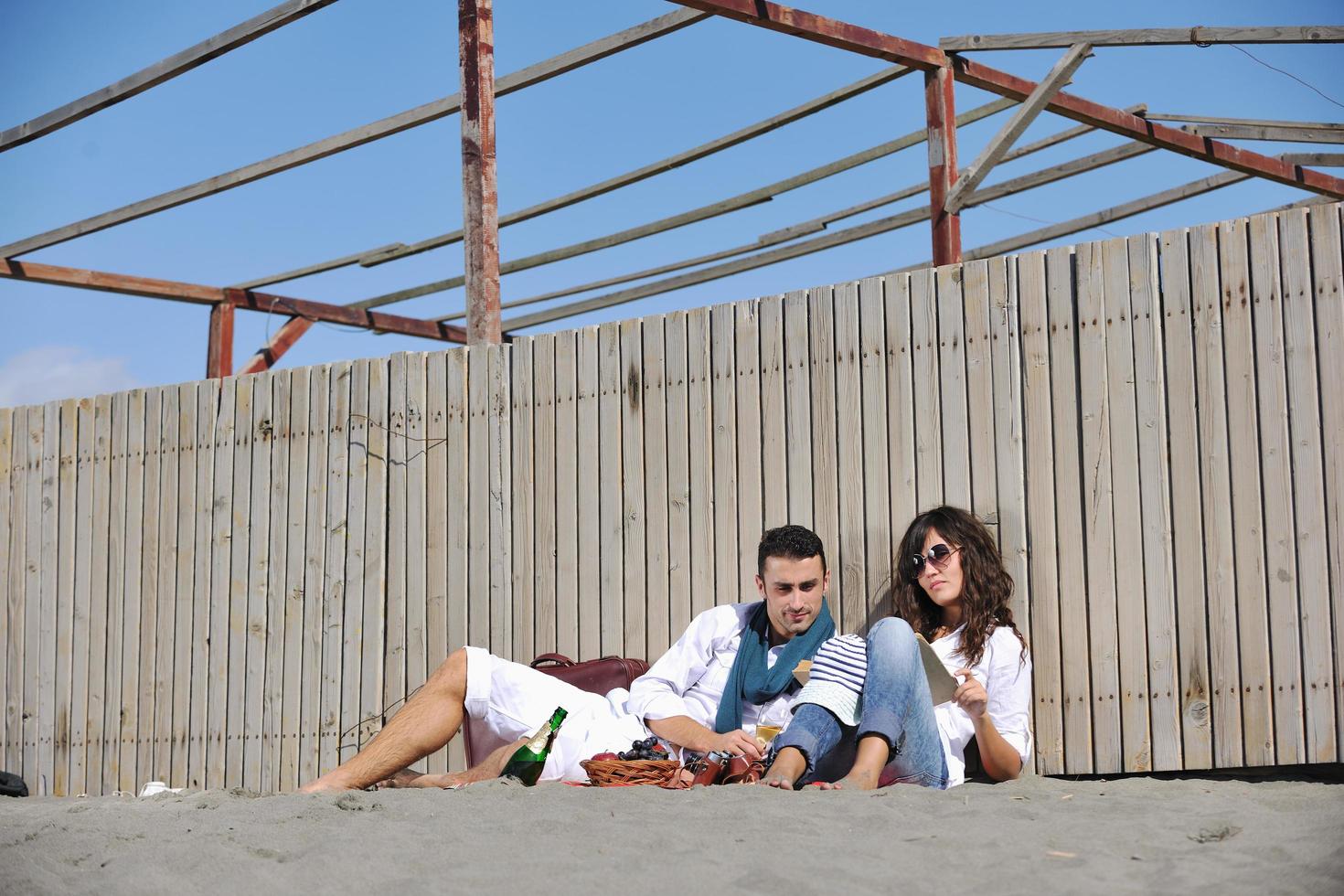 giovane coppia godendo picnic su il spiaggia foto