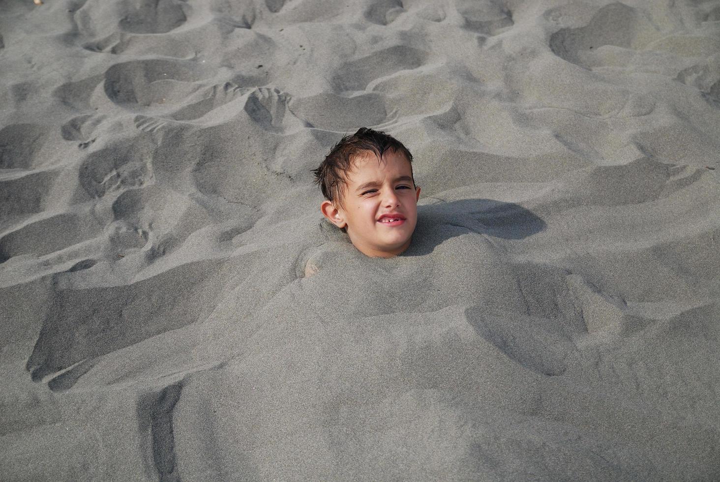 contento bambini sepolto nel sabbia foto