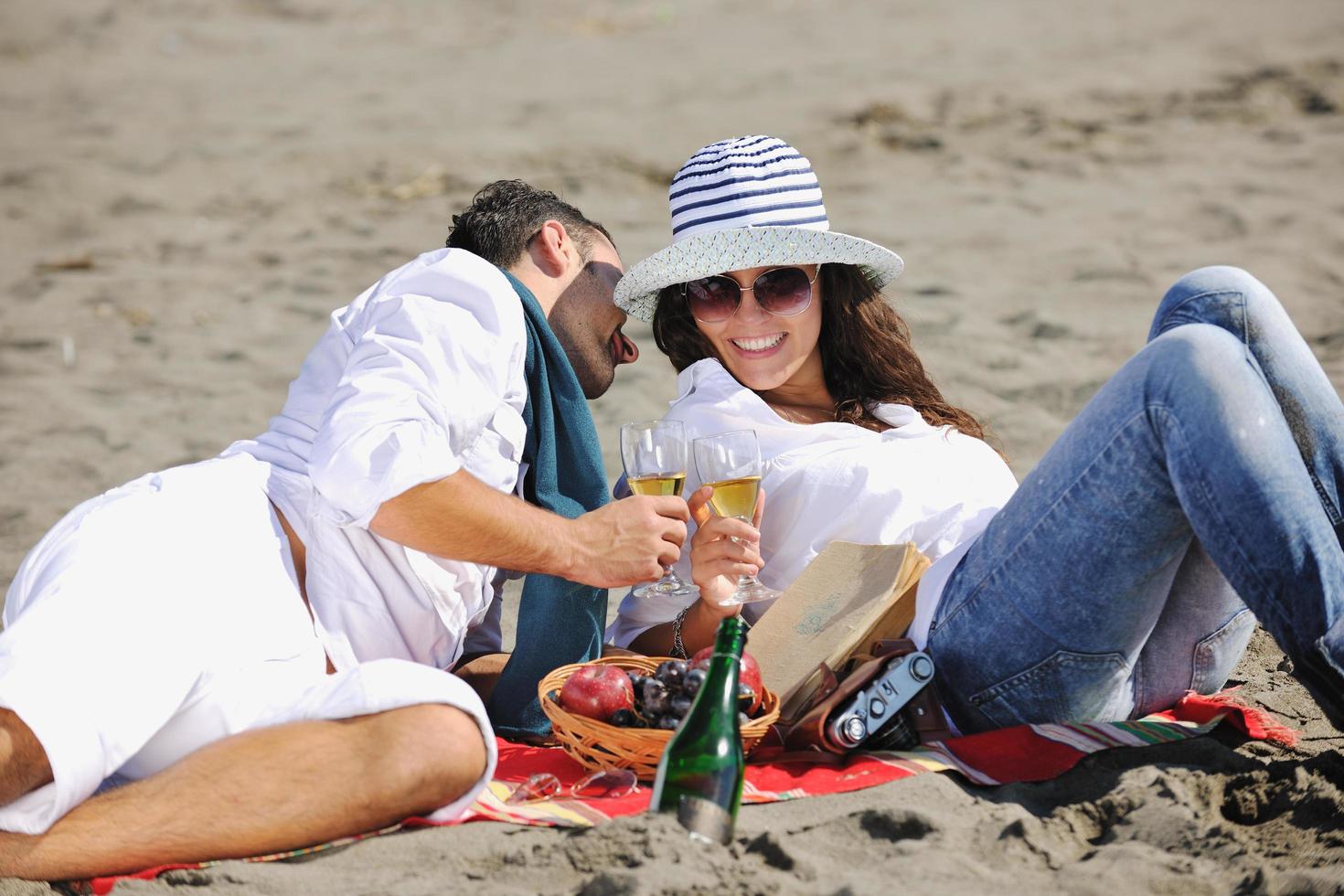 giovane coppia godendo picnic su il spiaggia foto