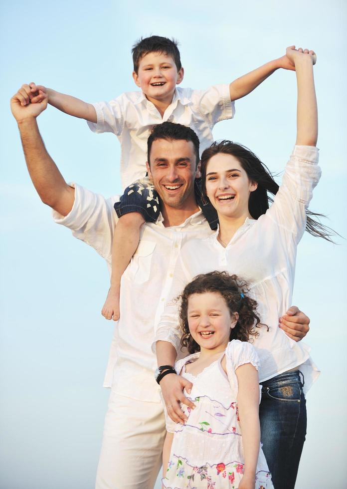 contento giovane famiglia avere divertimento su spiaggia foto