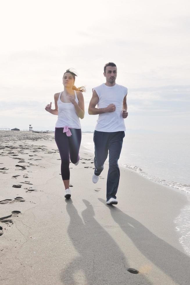 coppia jogging su il spiaggia foto