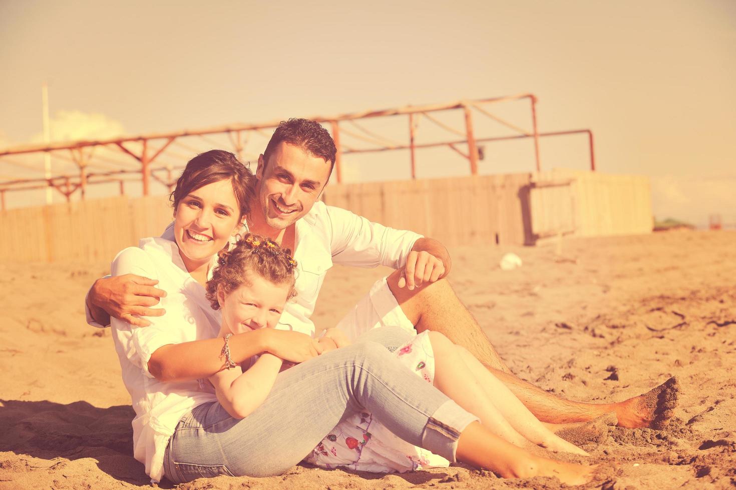 contento giovane famiglia avere divertimento su spiaggia foto