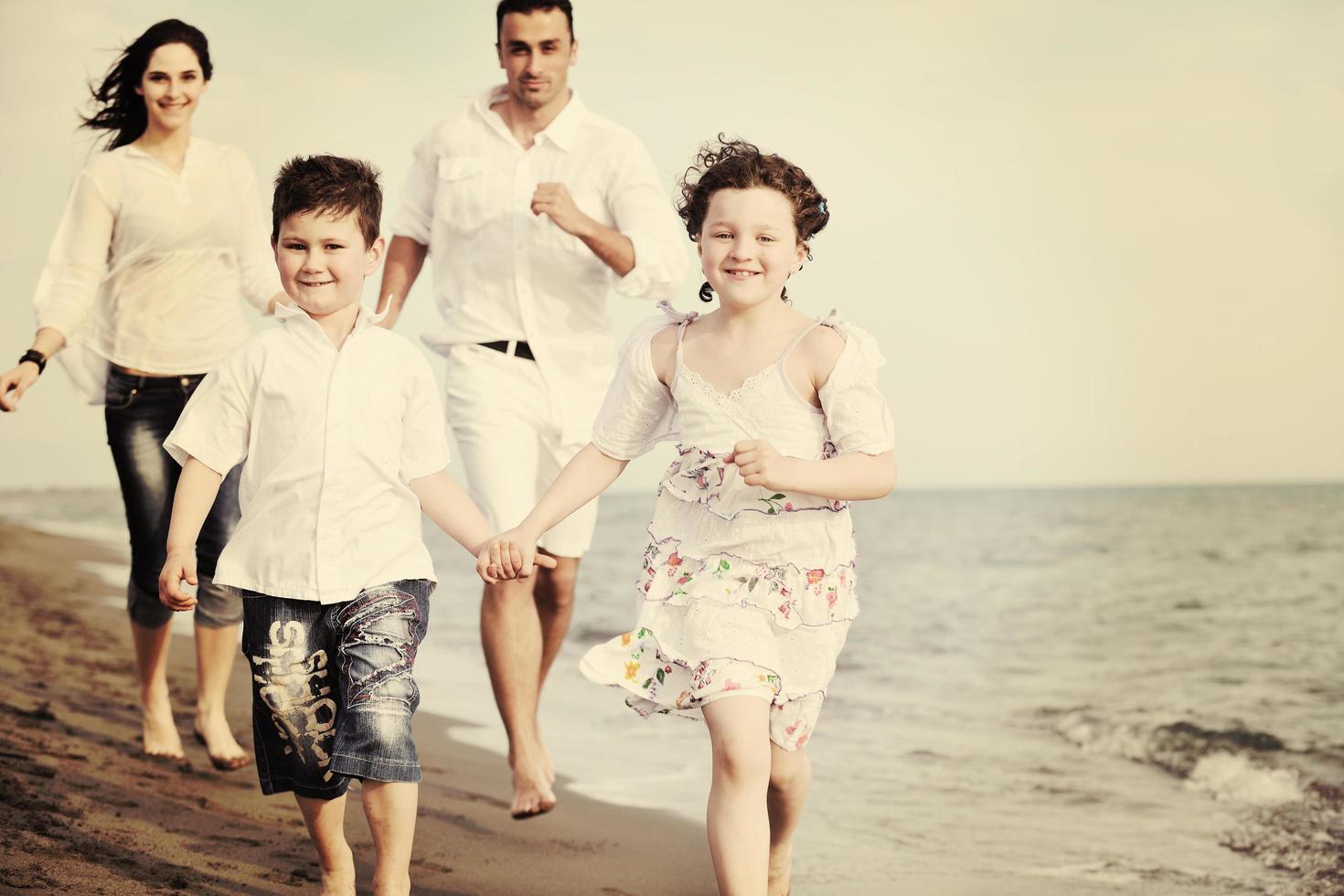 contento giovane famiglia avere divertimento su spiaggia foto