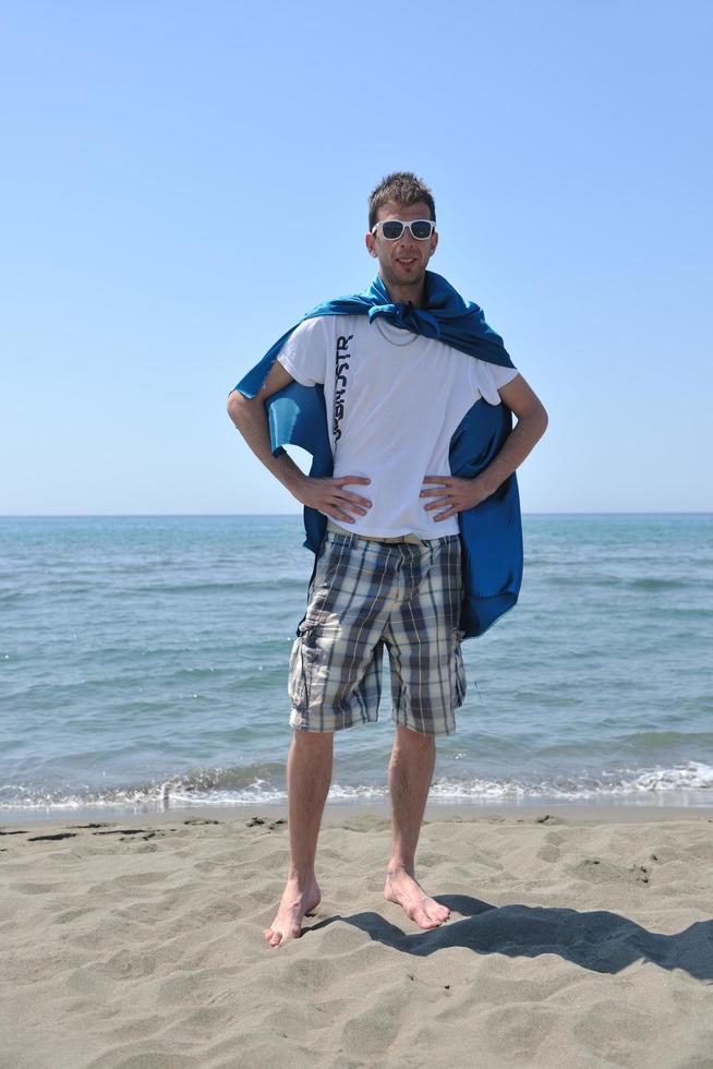 divertente supereroe in piedi su spiaggia foto