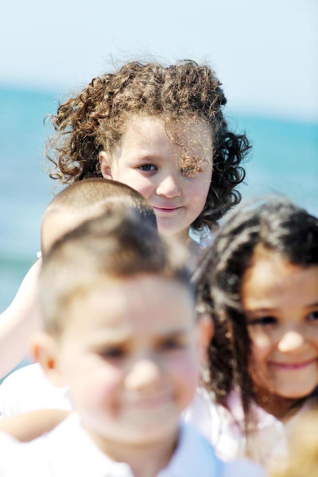 gruppo di bambini felici che giocano sulla spiaggia foto