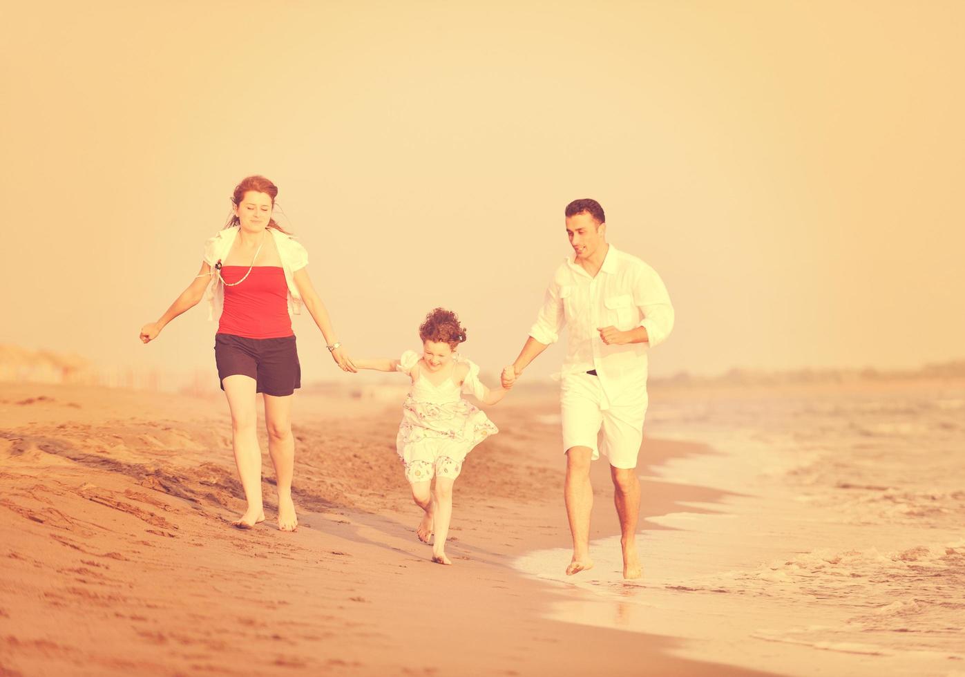 contento giovane famiglia avere divertimento su spiaggia foto