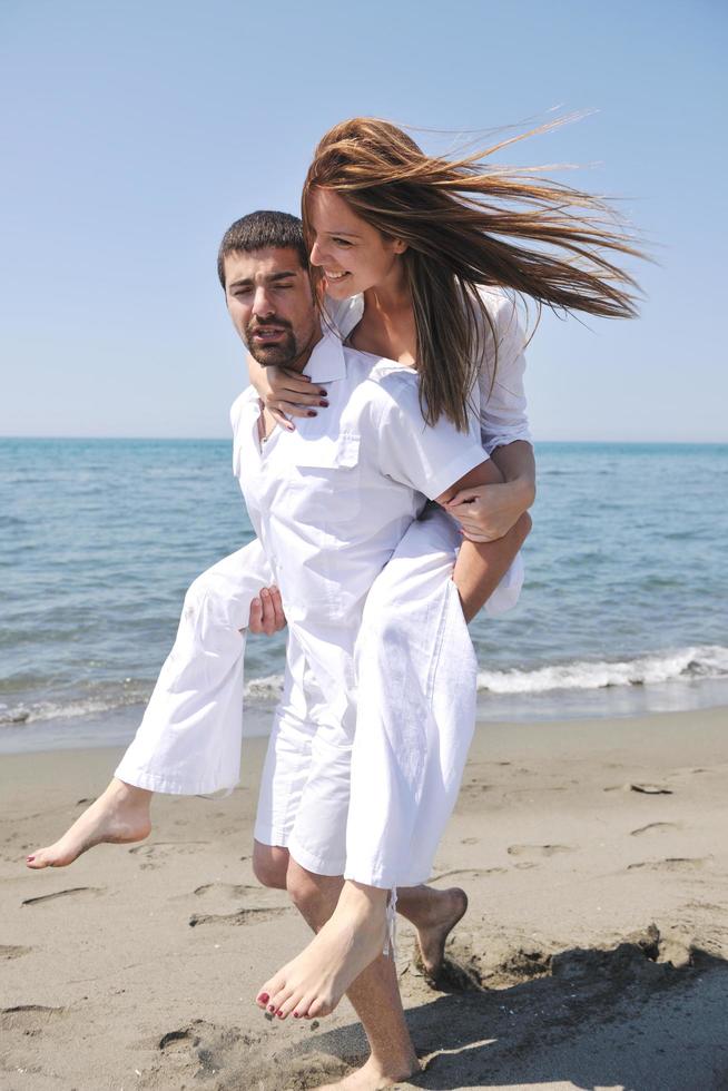 la giovane coppia felice si diverte sulla spiaggia foto