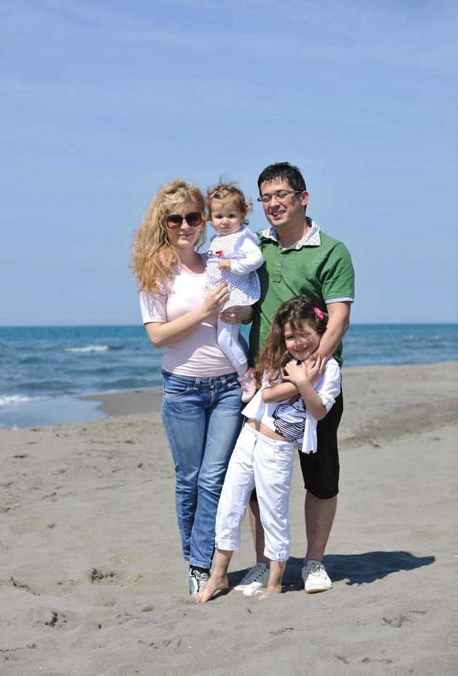 contento giovane famiglia avere divertimento su spiaggia foto