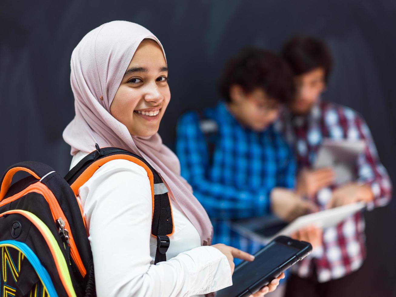 moderno arabo adolescenti uso smartphone, tavoletta e latpop per studia durante in linea classi dovuto per corona virus pandemia foto