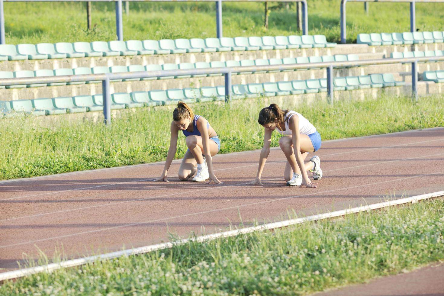 Due ragazze in esecuzione su atletico gara traccia foto