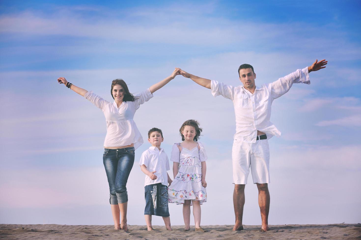 famiglia su spiaggia mostrando casa cartello foto