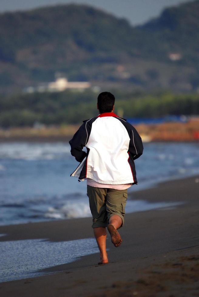 uomo jogging a spiaggia foto