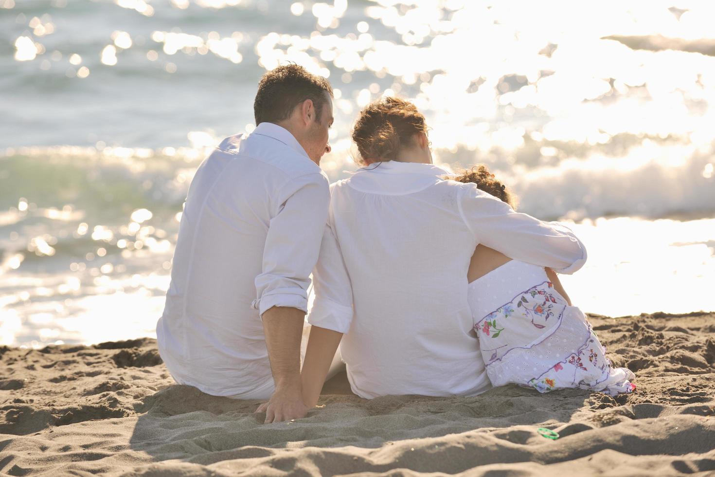 contento giovane famiglia avere divertimento su spiaggia foto