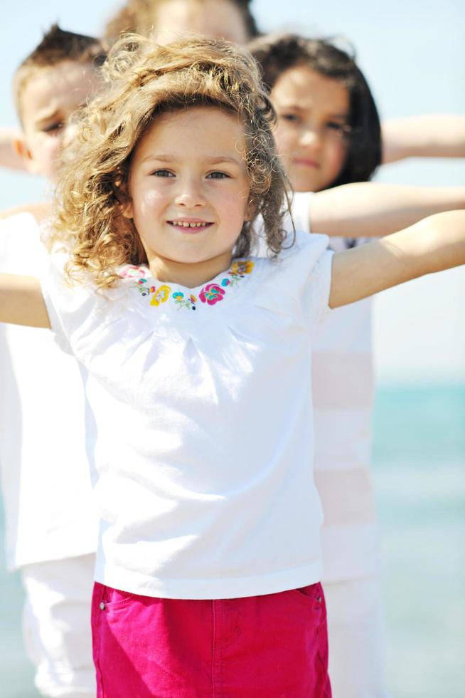 gruppo di bambini felici che giocano sulla spiaggia foto