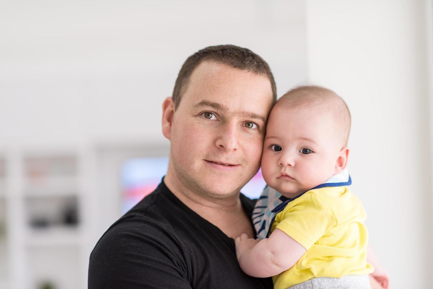 giovane padre Tenere bambino vicino il finestra a casa foto