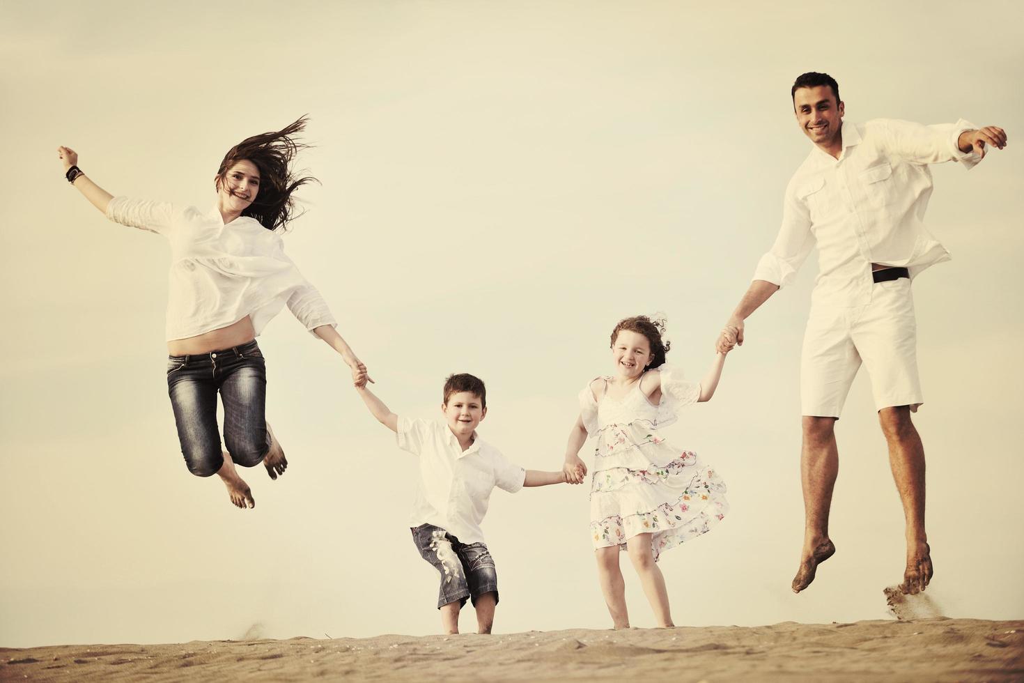 contento giovane famiglia avere divertimento su spiaggia foto