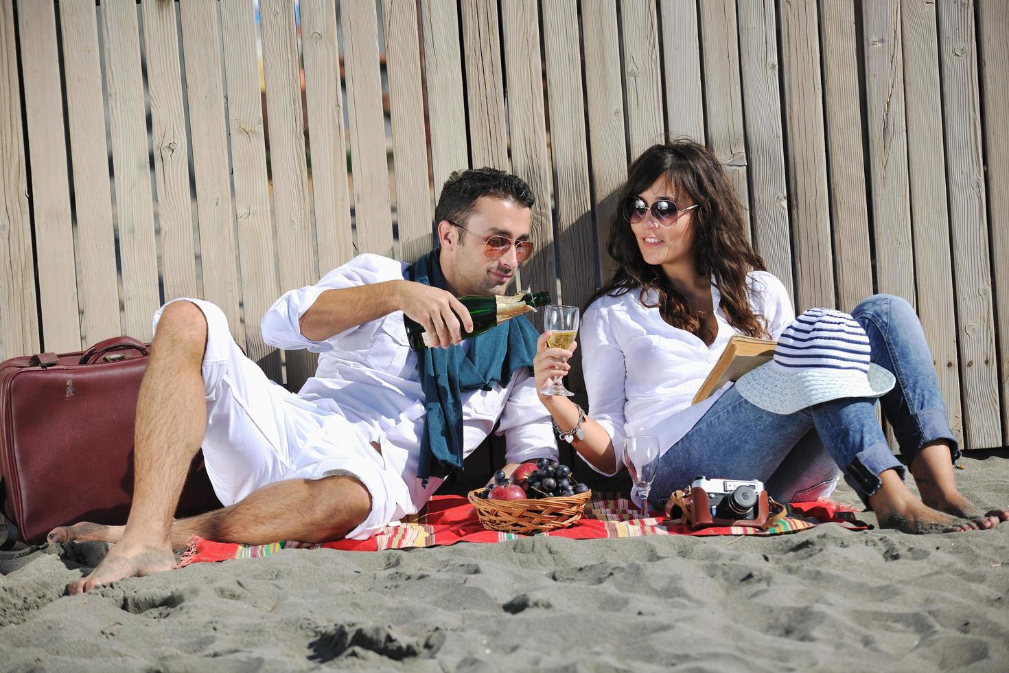 giovane coppia godendo picnic su il spiaggia foto