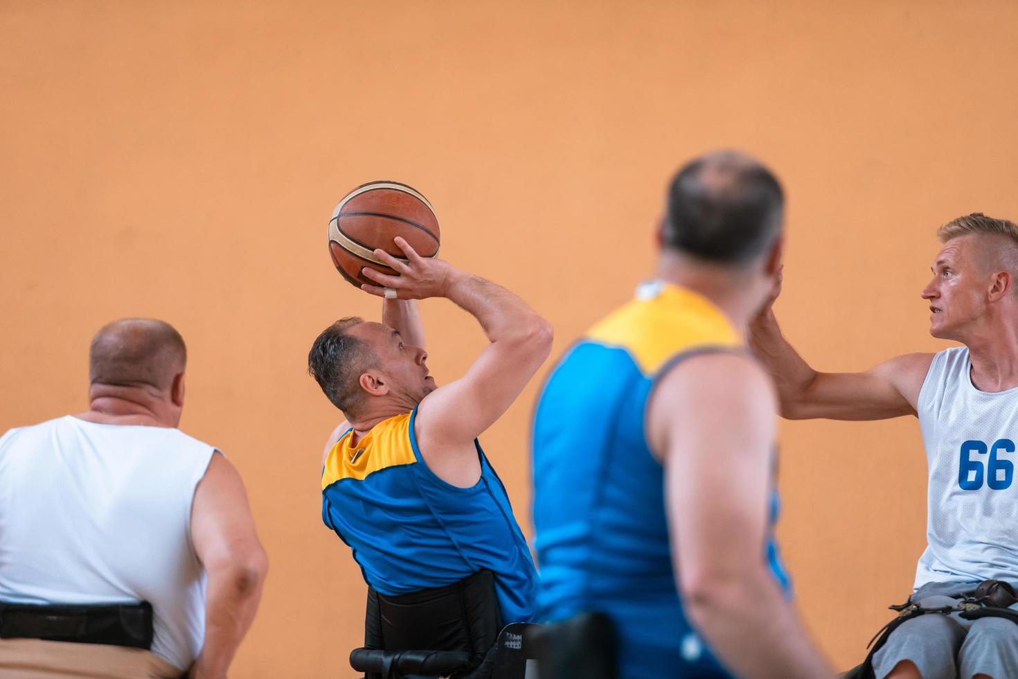 Disabilitato guerra veterani misto gara e età pallacanestro squadre nel sedie a rotelle giocando un' formazione incontro nel un' gli sport Palestra sala. portatori di handicap persone reinserimento e inclusione concetto foto