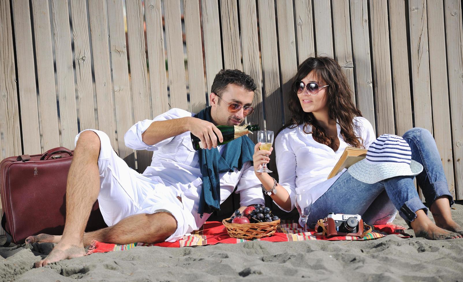 giovane coppia godendo picnic su il spiaggia foto