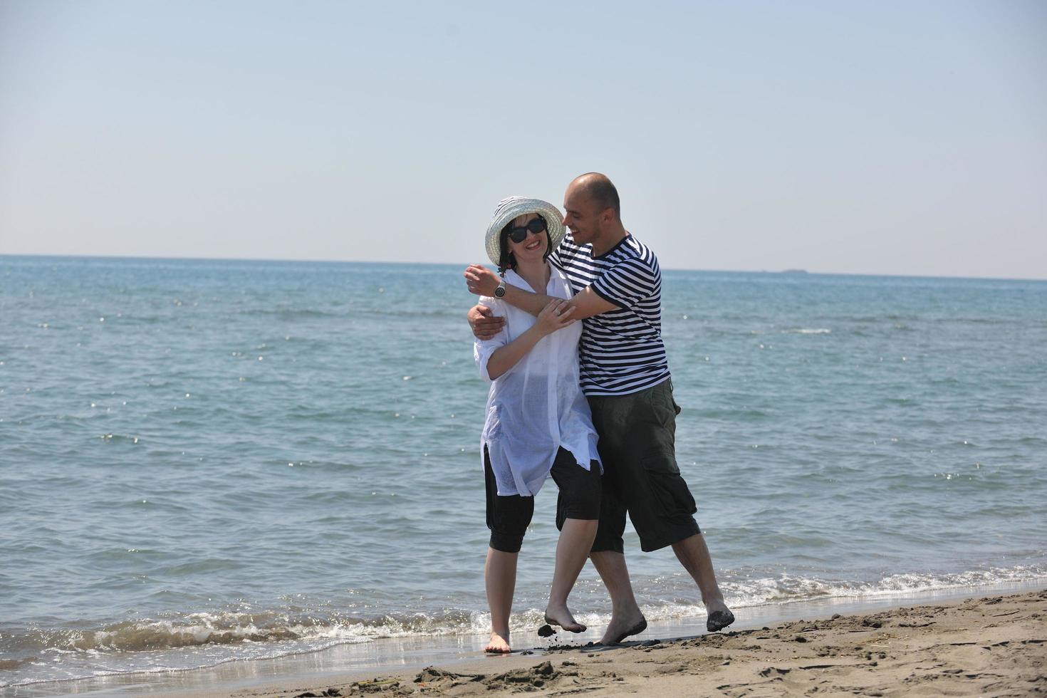 la giovane coppia felice si diverte sulla spiaggia foto