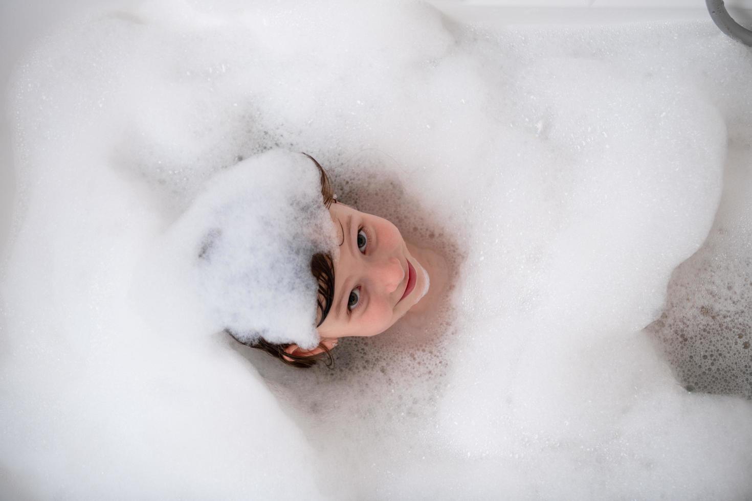 superiore Visualizza di poco ragazza nel bagno giocando con schiuma foto