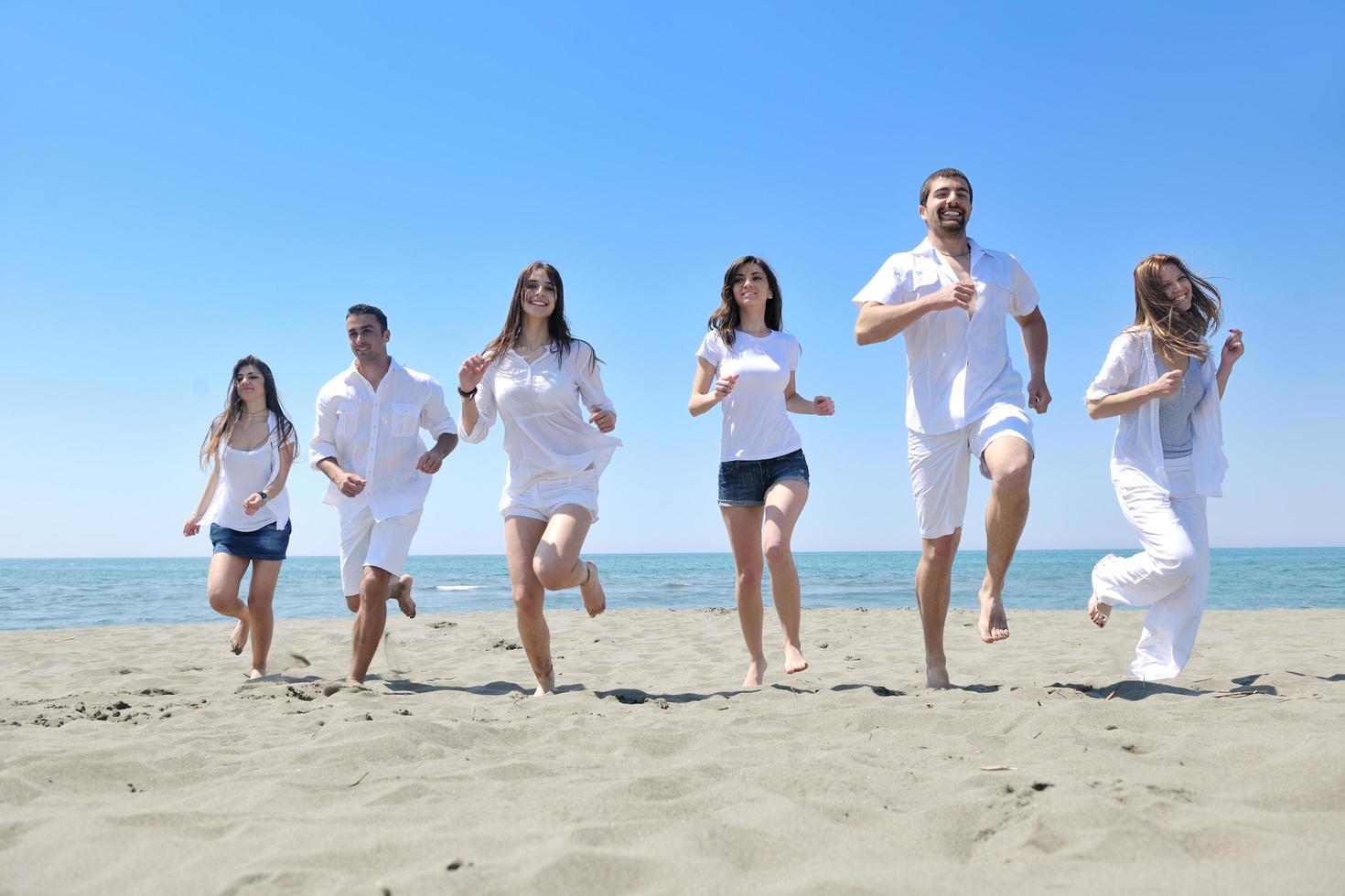 contento giovane persone gruppo avere divertimento su spiaggia foto