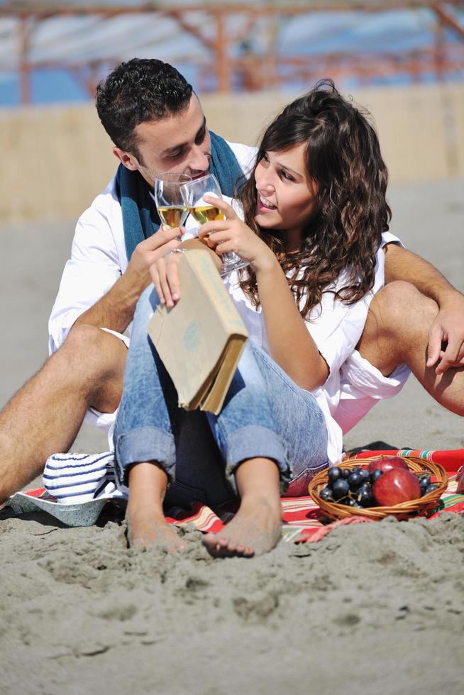 giovane coppia godendo picnic su il spiaggia foto