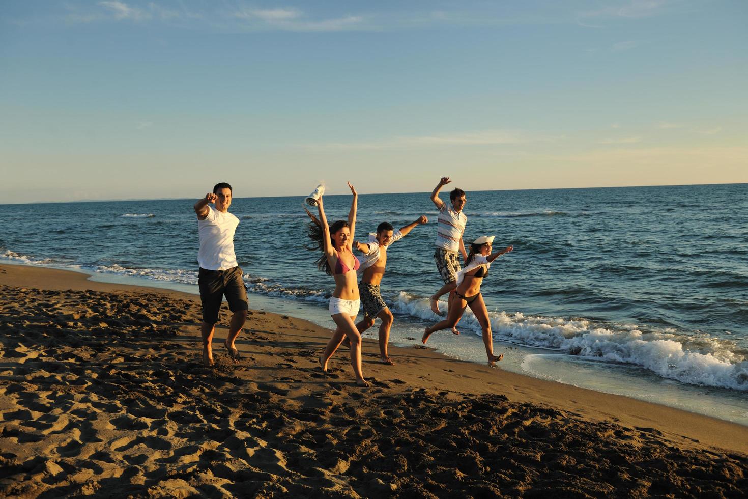 persone gruppo in esecuzione su il spiaggia foto