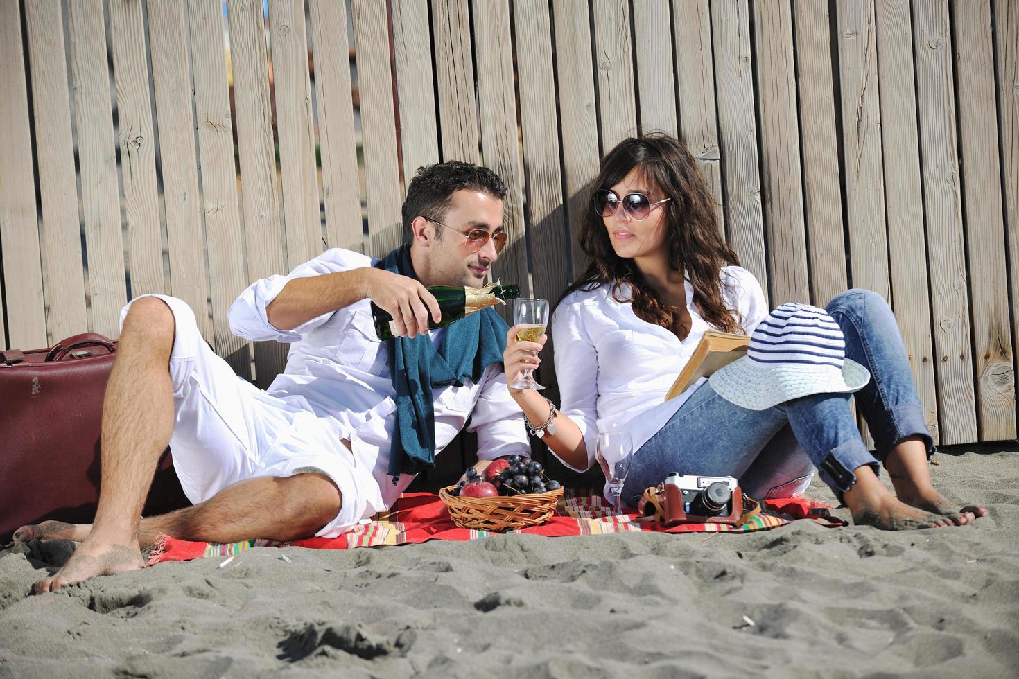 giovane coppia godendo picnic su il spiaggia foto