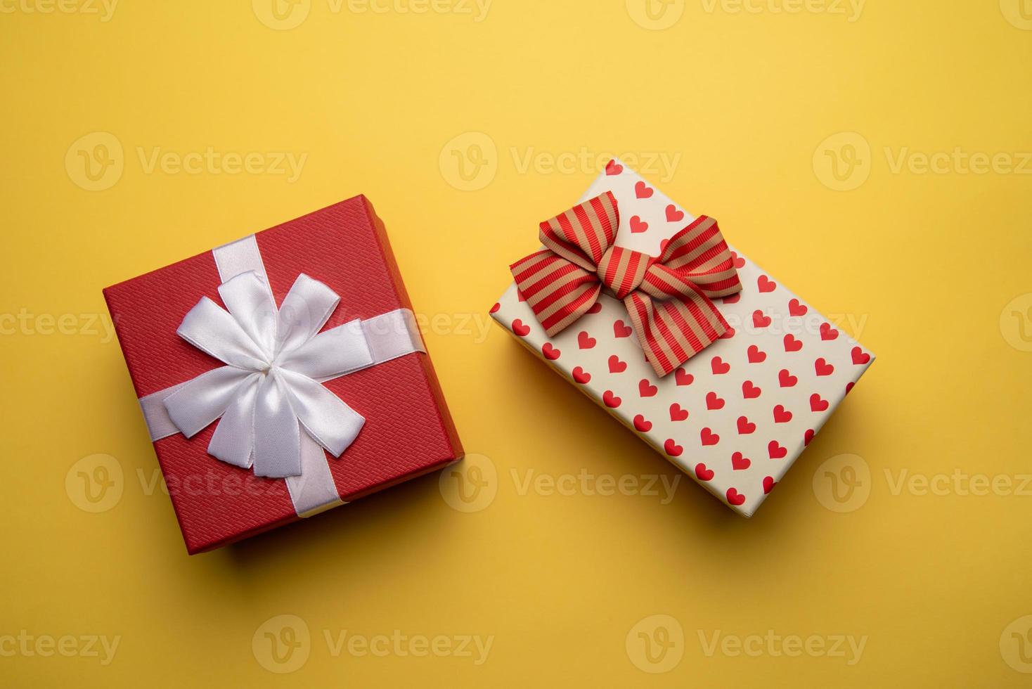 rosso e bianca regalo scatola con su giallo sfondo, piatto posare foto