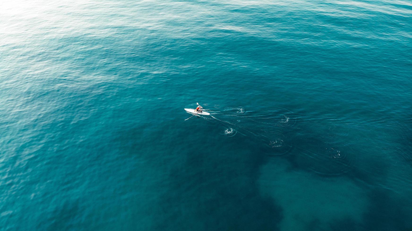 uomo che rema sul mare foto