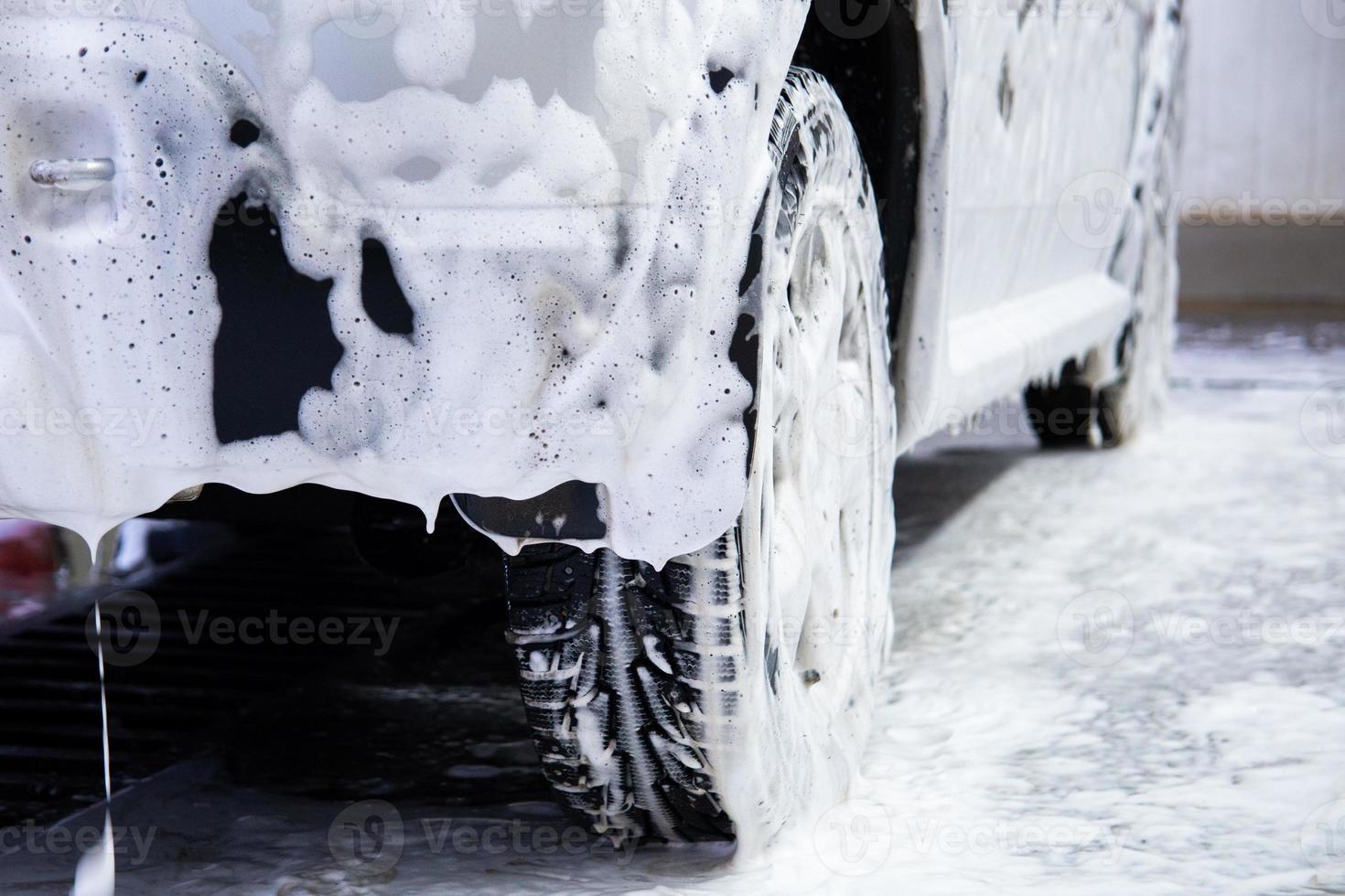 un' auto coperto di sapone schiuma mentre lavaggio in casa - avvicinamento Basso posizione Visualizza a partire dal indietro con selettivo messa a fuoco foto