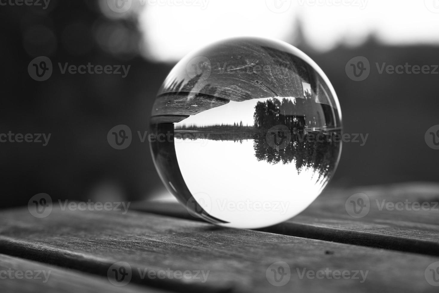 bicchiere palla su un' di legno molo a un' svedese lago a crepuscolo nel nero e bianca. natura foto