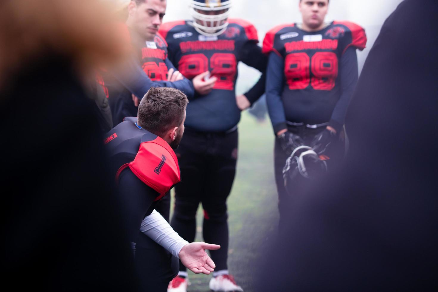 americano calcio giocatore discutere strategia con il suo squadra foto