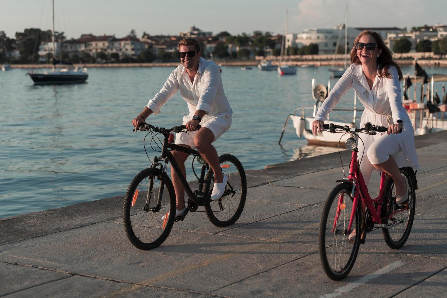 anziano coppia godendo un' bellissimo mattina insieme equitazione un' bicicletta di il mare. selettivo messa a fuoco foto